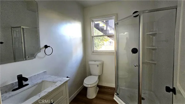 a bathroom with a granite countertop toilet a sink and a shower