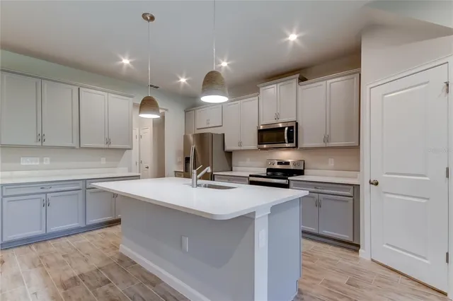 a kitchen with a sink a stove a refrigerator and cabinets
