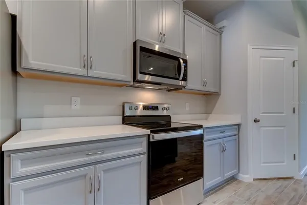 a kitchen with white cabinets and stainless steel appliances
