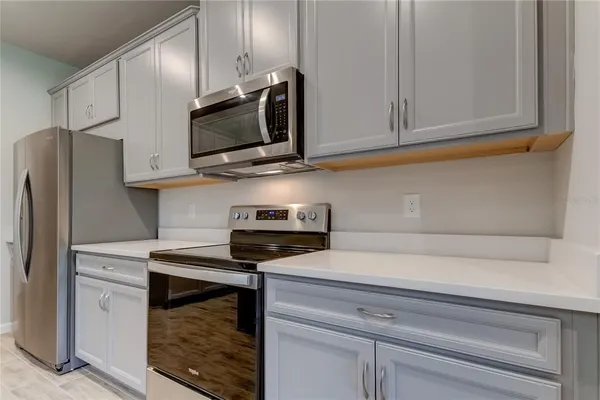 a kitchen with a stove a refrigerator and a microwave