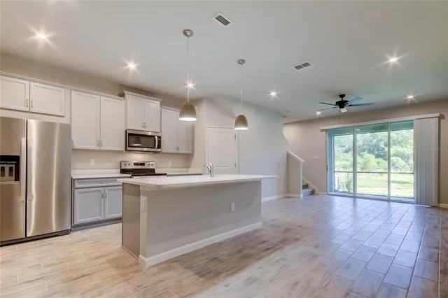 a kitchen with stainless steel appliances a refrigerator sink and microwave