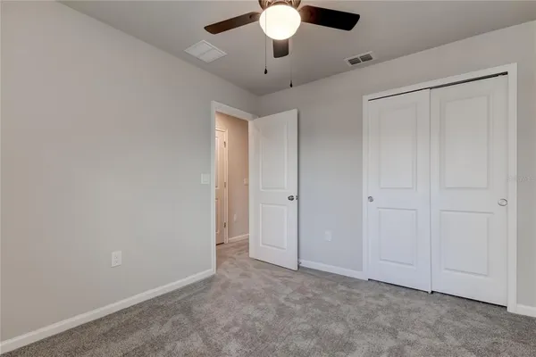 an empty room with a window and a fan