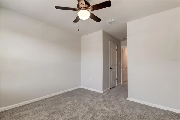 an empty room with a window and a fan