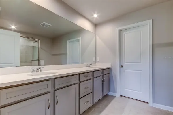 a bathroom with a double vanity sink and a mirror