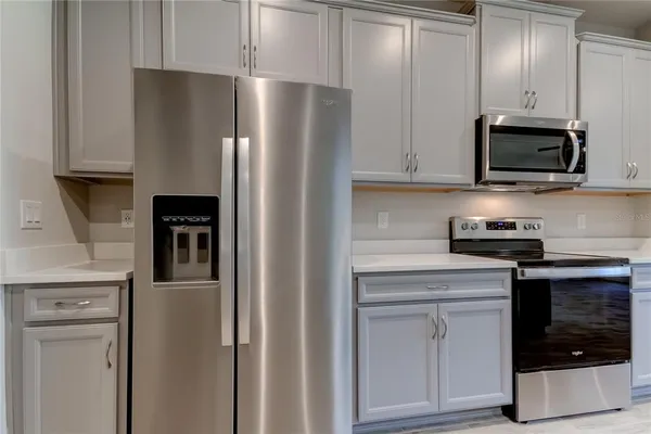 a kitchen with stainless steel appliances white cabinets and a refrigerator
