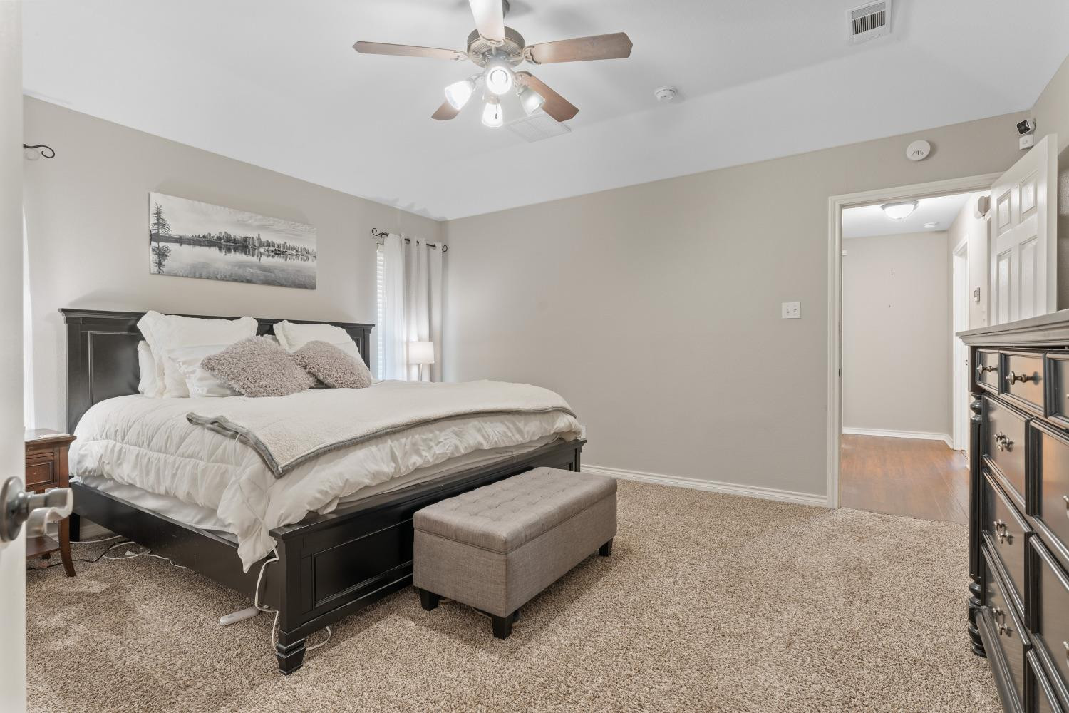 5614 100th Street Lubbock, TX 79424 - Photo 13 of 27 a bedroom with a bed and a chandelier