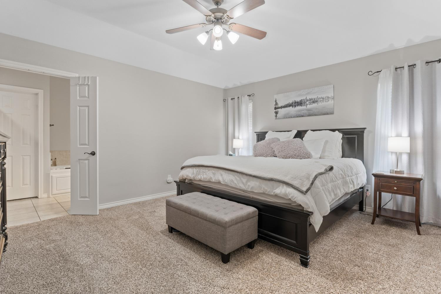 5614 100th Street Lubbock, TX 79424 - Photo 14 of 27 a spacious bedroom with a bed and a chandelier