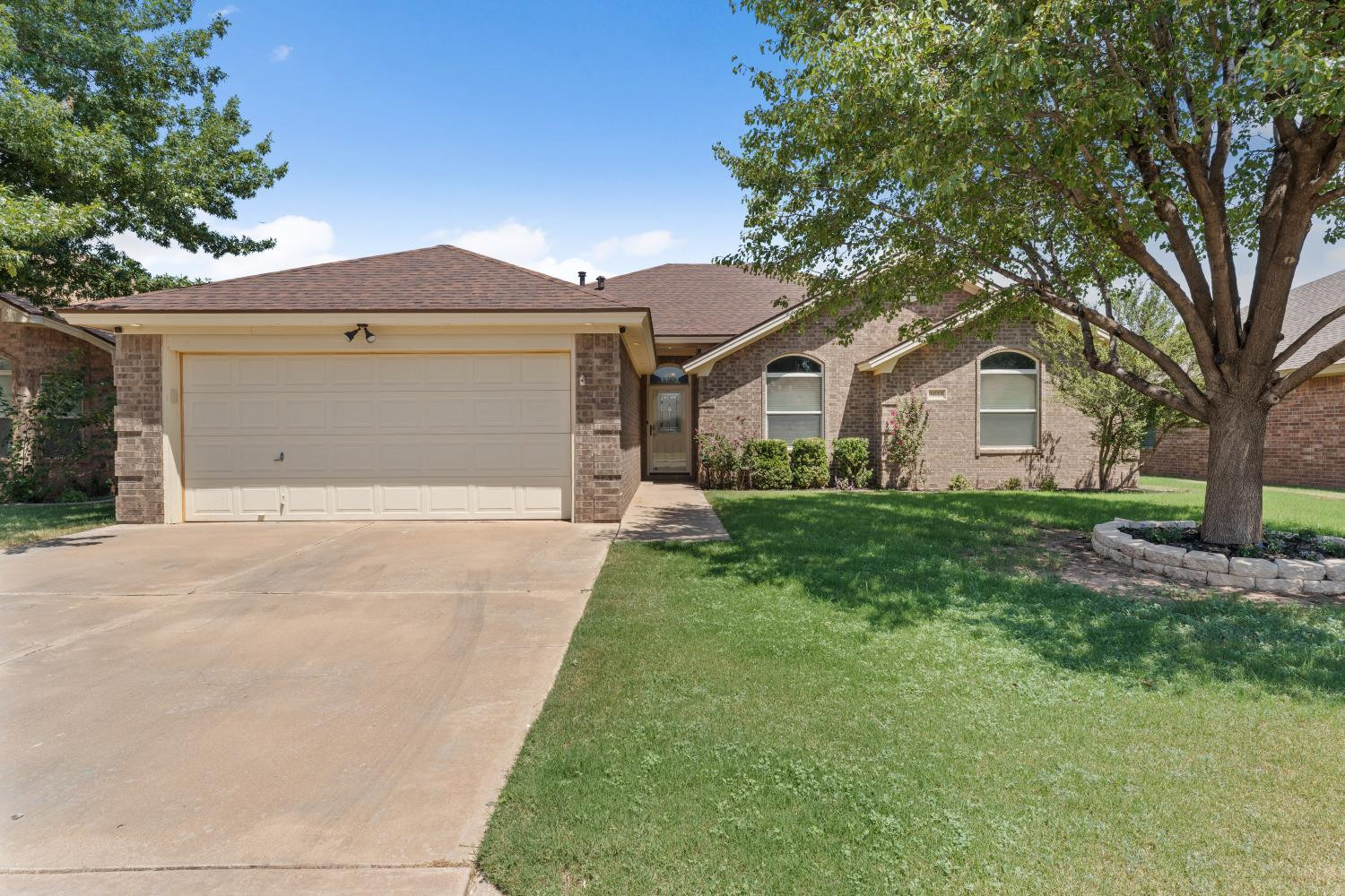 5614 100th Street Lubbock, TX 79424 - Photo 2 of 27 a front view of a house with a yard and garage