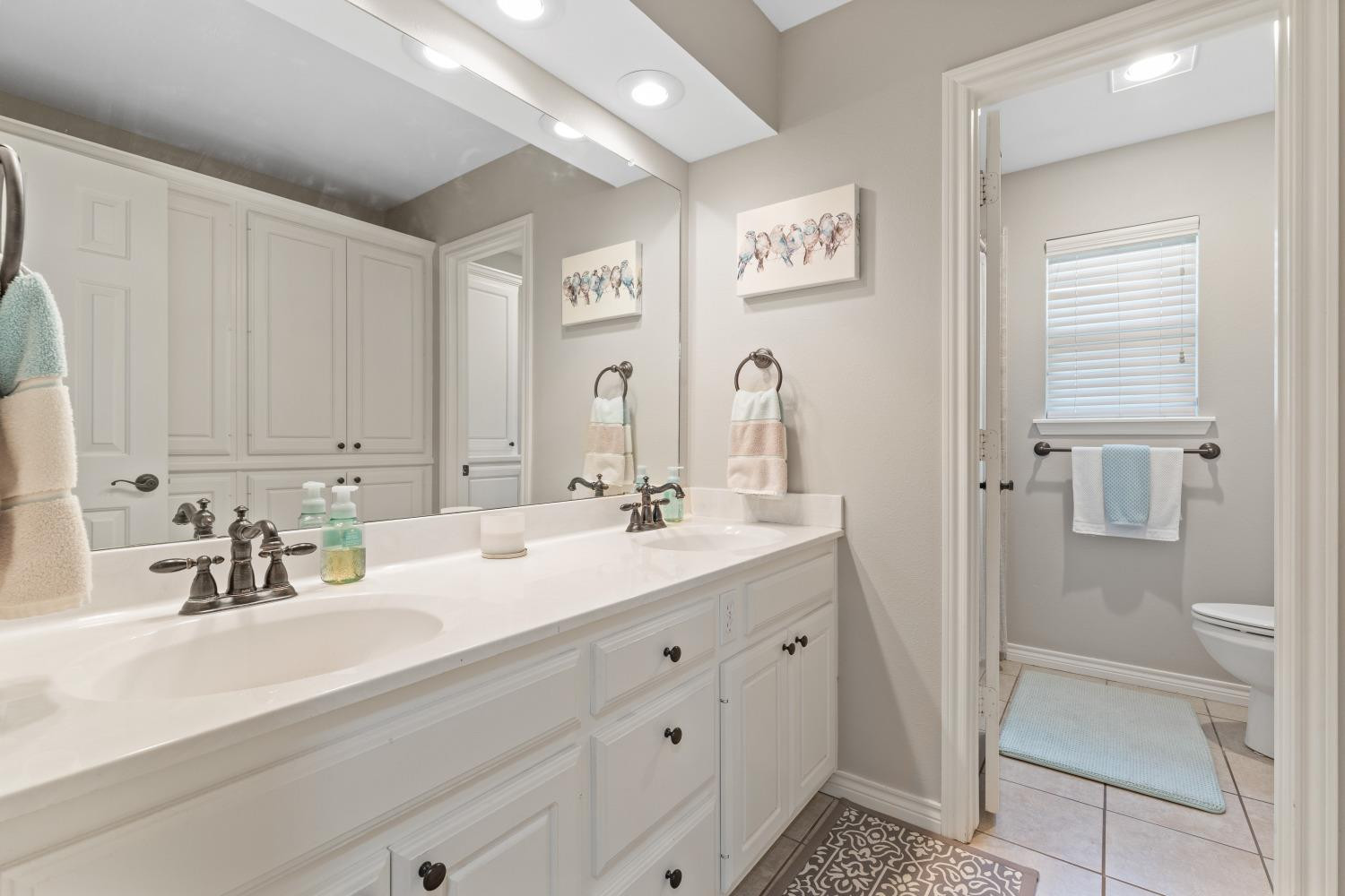 5614 100th Street Lubbock, TX 79424 - Photo 22 of 27 a bathroom with a sink and a mirror