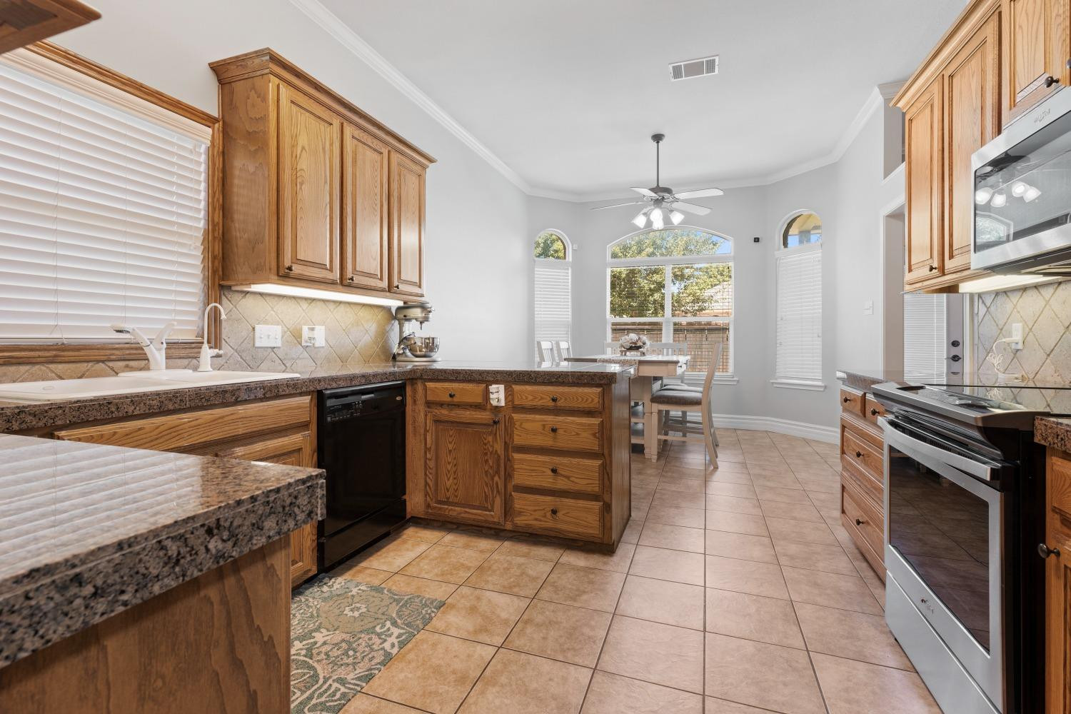 5614 100th Street Lubbock, TX 79424 - Photo 10 of 27 a kitchen with a sink stove and cabinets