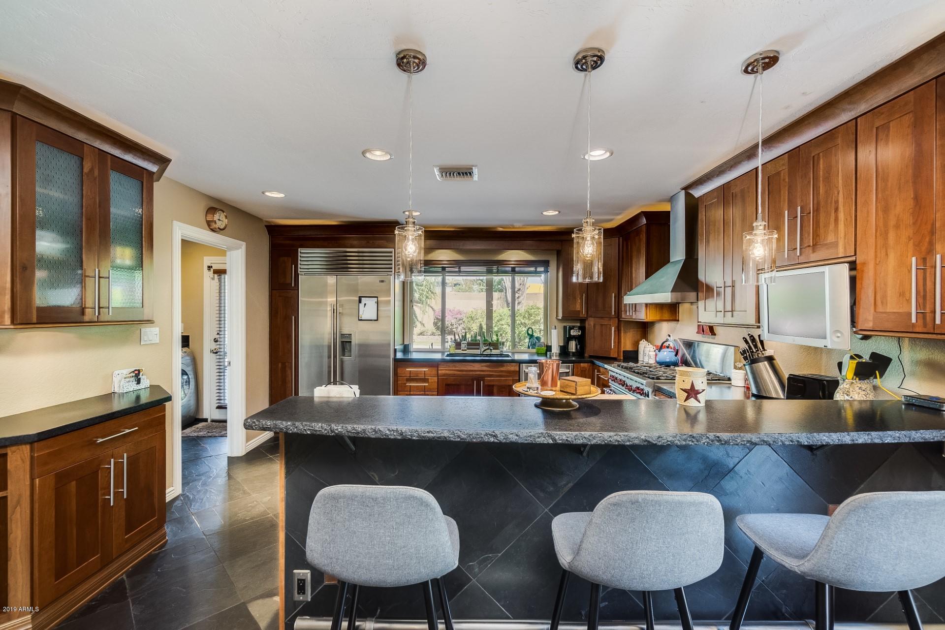 5319 North 15th Street Phoenix, AZ 85014 - Photo 13 of 33 a kitchen with a table chairs stove and kitchen island