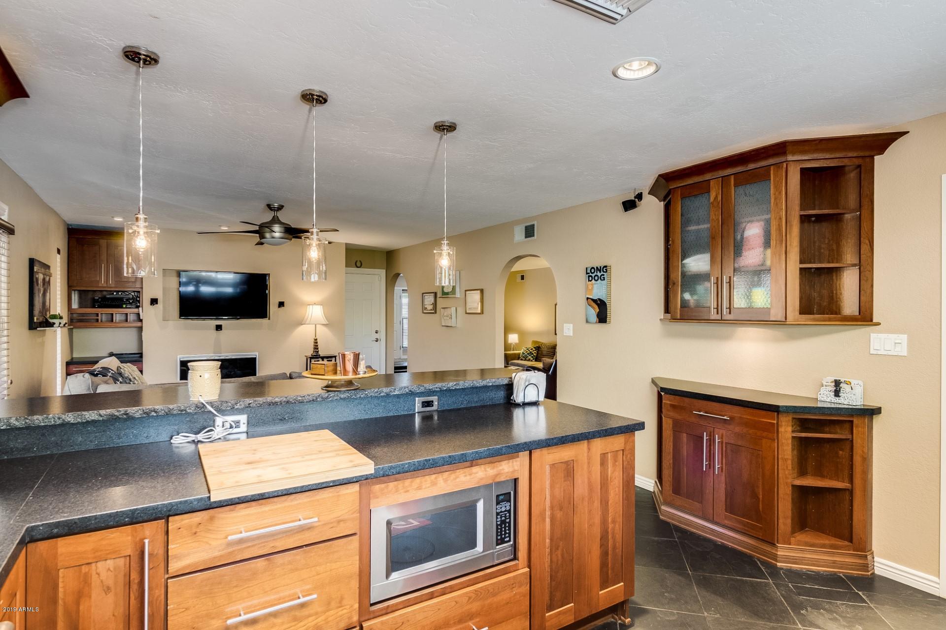 5319 North 15th Street Phoenix, AZ 85014 - Photo 18 of 33 a kitchen with stainless steel appliances granite countertop a sink a stove and a wooden cabinets