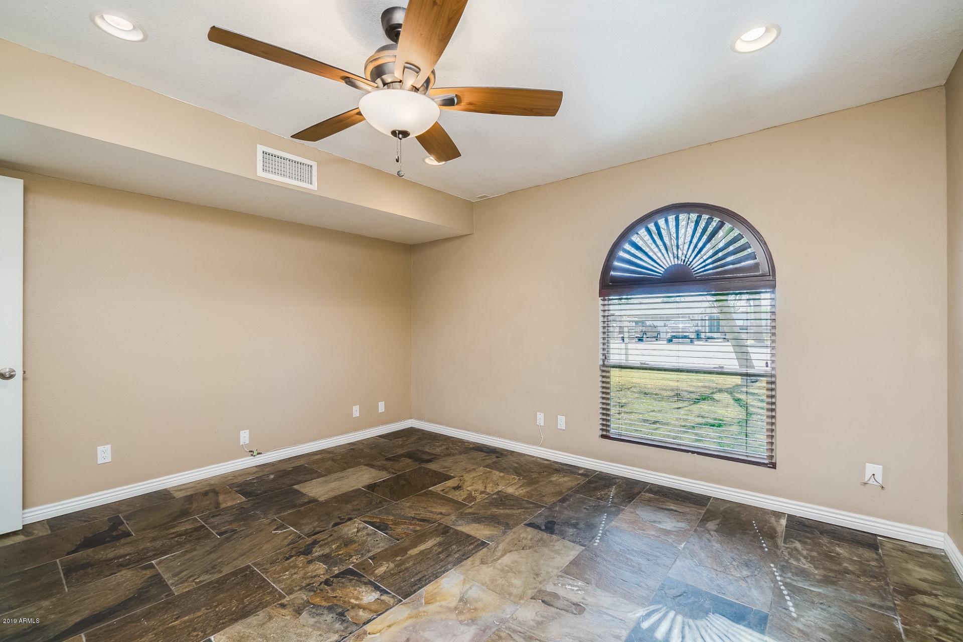 5319 North 15th Street Phoenix, AZ 85014 - Photo 26 of 33 an empty room with wooden floor and ceiling fan