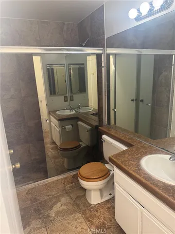 a bathroom with a granite countertop sink toilet and shower