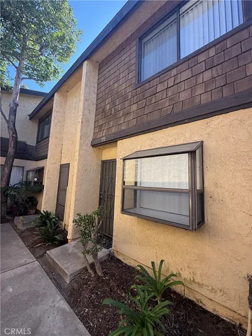a view of backyard with potted plants and wooden fence