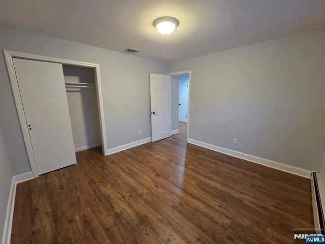 an empty room with wooden floor and closet