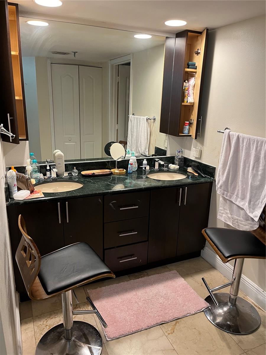 520 Brickell Key Drive, Unit A610 Miami, FL 33131 - Photo 3 of 10 a room with a chair a sink and a mirror