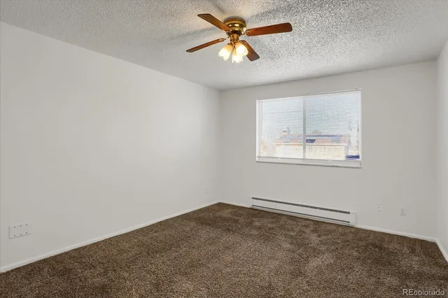 an empty room with a window and a fan