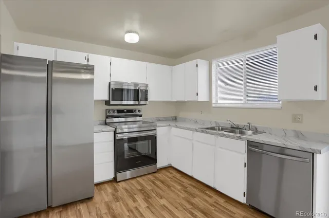 a kitchen with stainless steel appliances granite countertop a stove a sink and a refrigerator