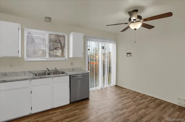 a kitchen with a sink cabinets and wooden floor