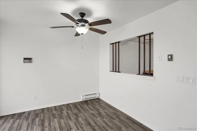 a view of a hallway with wooden floor and a ceiling fan