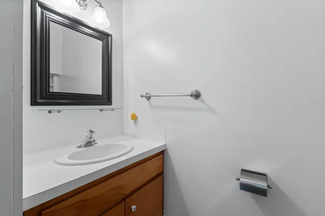 a bathroom with a sink vanity and a mirror