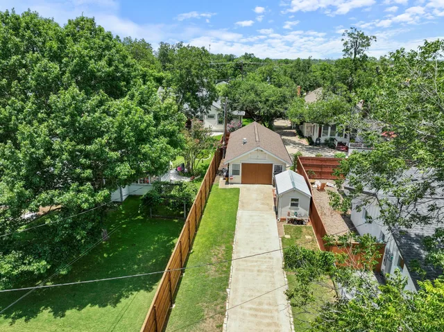 an aerial view of residential houses with outdoor space and trees