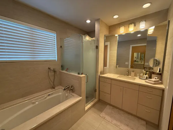 a bathroom with a tub sink and mirror