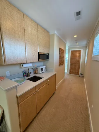 a kitchen with a sink a stove top oven and cabinets
