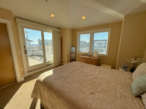 a bedroom with a large bed and large windows