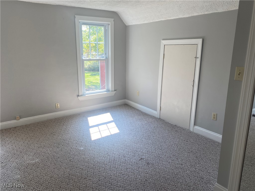 3016 Wadsworth Road Norton, OH 44203 - Photo 38 of 50 Carpeted spare room featuring a textured ceiling and vaulted ceiling
