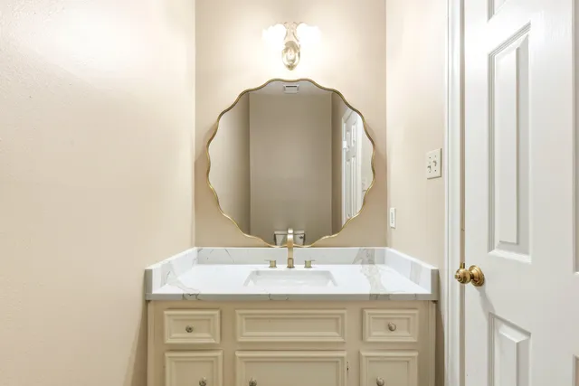 a view of an empty room with wooden floor and fan