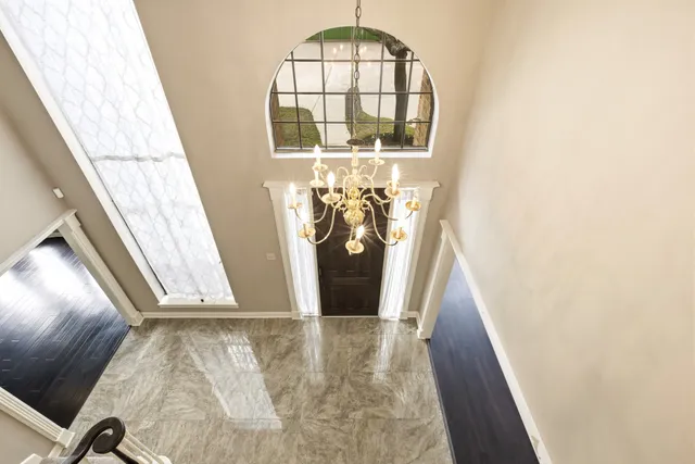a view of an empty room with a window and kitchen area