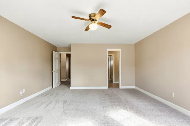 an empty room with closet and windows