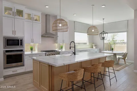 a kitchen with stainless steel appliances granite countertop a stove a sink a oven a dining table and chairs with wooden floor