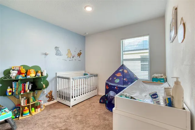 a bedroom with baby bed toys and a window