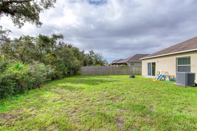 a backyard of a house with plants and large trees