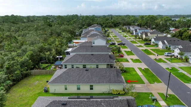 an aerial view of multiple houses with a yard