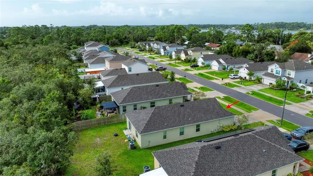 an aerial view of a house with a yard and lake view
