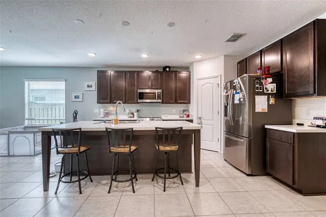a kitchen with stainless steel appliances granite countertop a refrigerator and a stove top oven