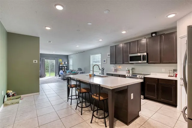 a large kitchen with kitchen island a sink counter space and stainless steel appliances