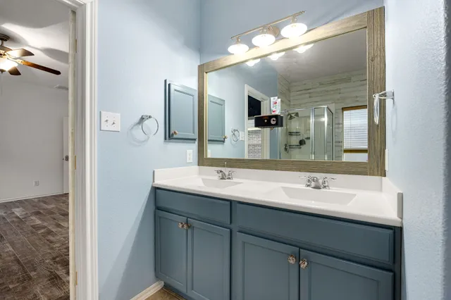 a bathroom with a double vanity sink and a mirror