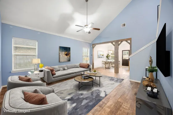 a living room with furniture a flat screen tv and a large window