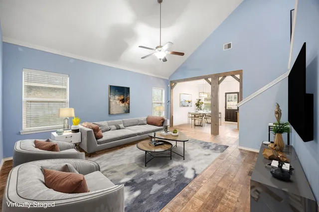 a living room with furniture a flat screen tv and a large window