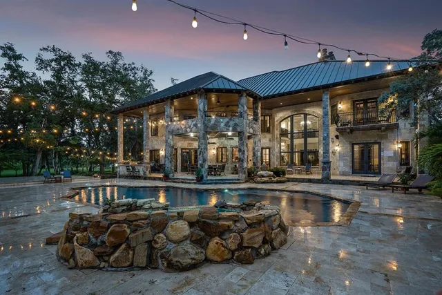a living room with furniture a large window and red chandelier