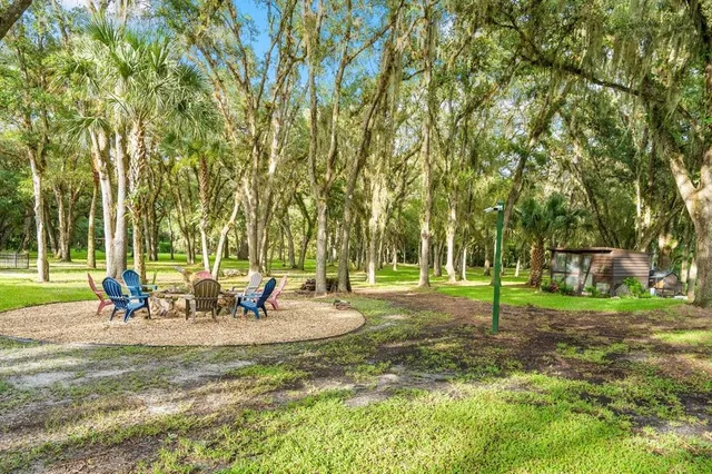 an aerial view of residential houses with outdoor space and trees