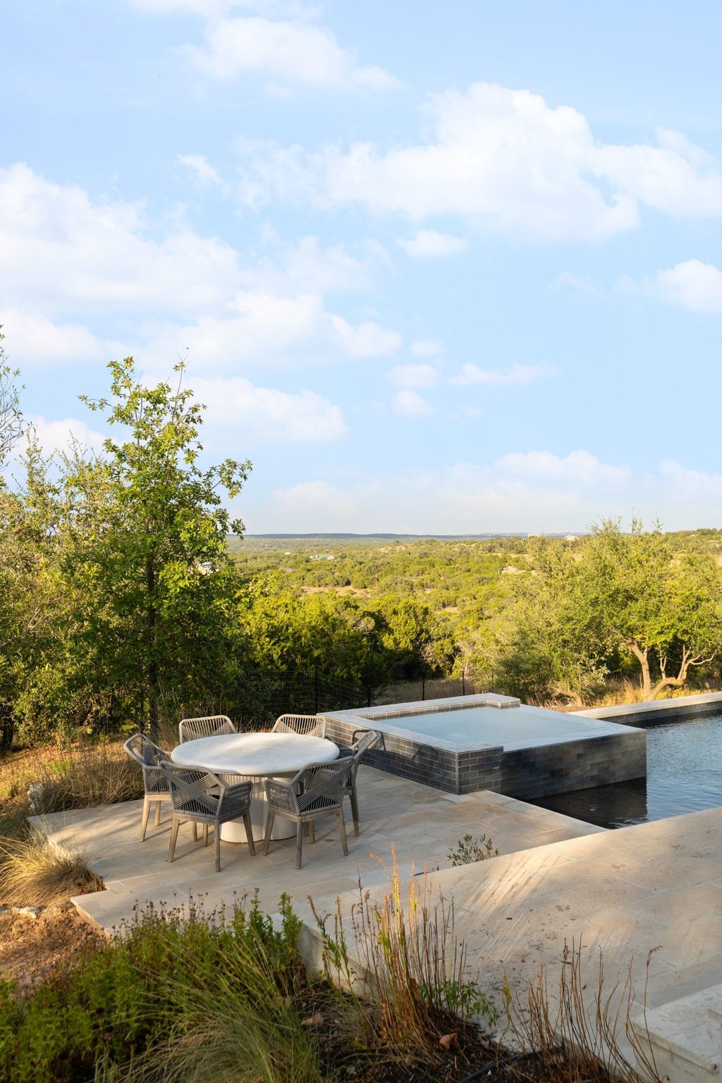 32045 Mirela Ann Road Dripping Springs, TX 78620 - Photo 27 of 30 A stone terrace sits beside an elevated pool, framing sweeping views of the rolling landscape.