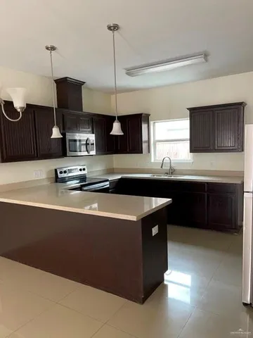 a kitchen with stainless steel appliances granite countertop a sink a stove and a refrigerator