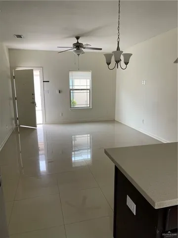 a view of a room with a chandelier fan and wooden floor