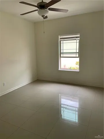 en empty room with windows and chandelier fan